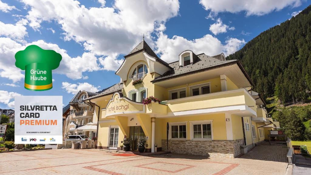 a large yellow building with a sign in front of it at Hotel Ischgl in Ischgl