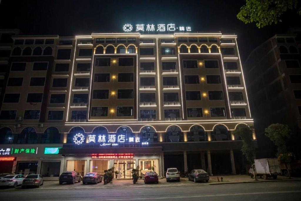 un edificio con un cartel encima por la noche en Morninginn, Qiyang High -speed Railway Station en Qiyang