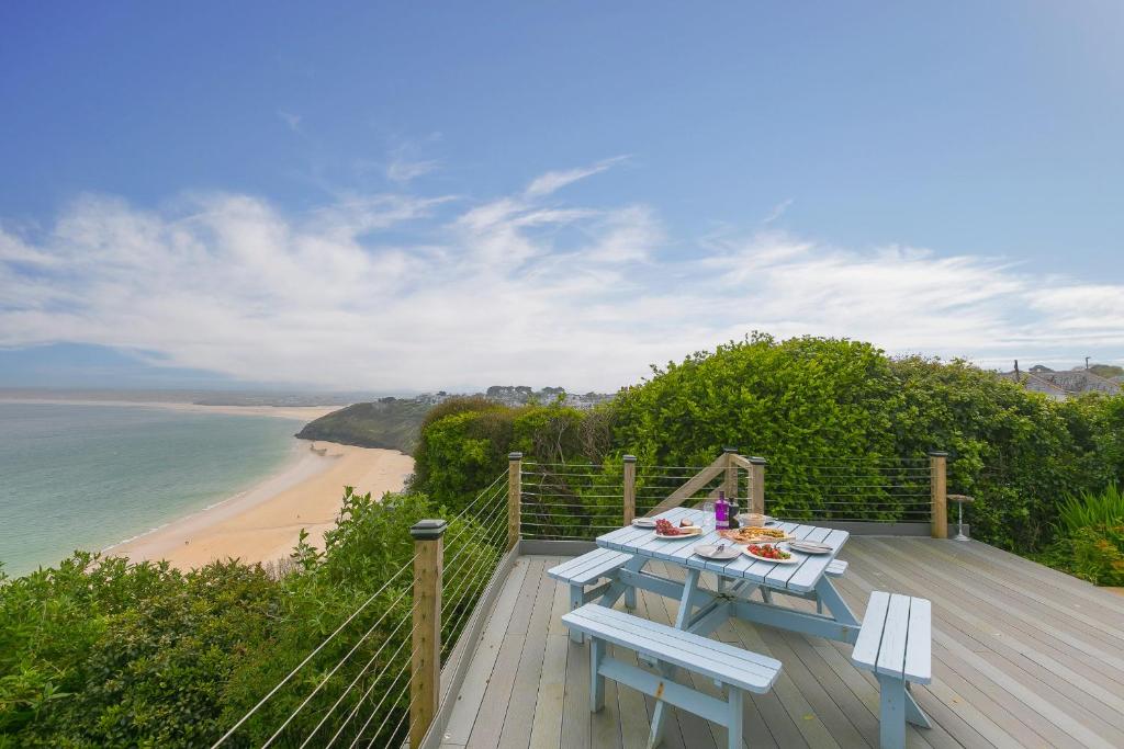 una mesa de picnic en una terraza con vistas a la playa en Moonbeams, en St Ives