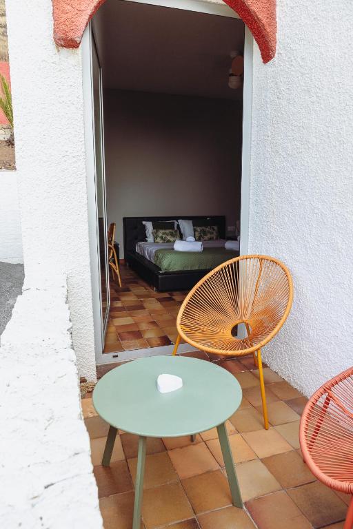 a patio with a table and a chair and a couch at Porto Santo Destination in Porto Santo