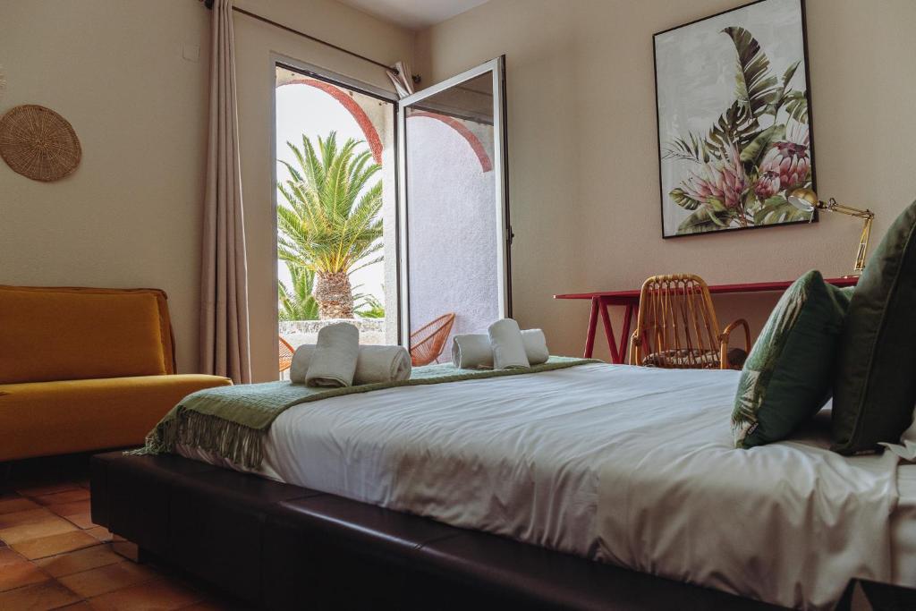 a bedroom with a bed and a large window at Porto Santo Destination in Porto Santo