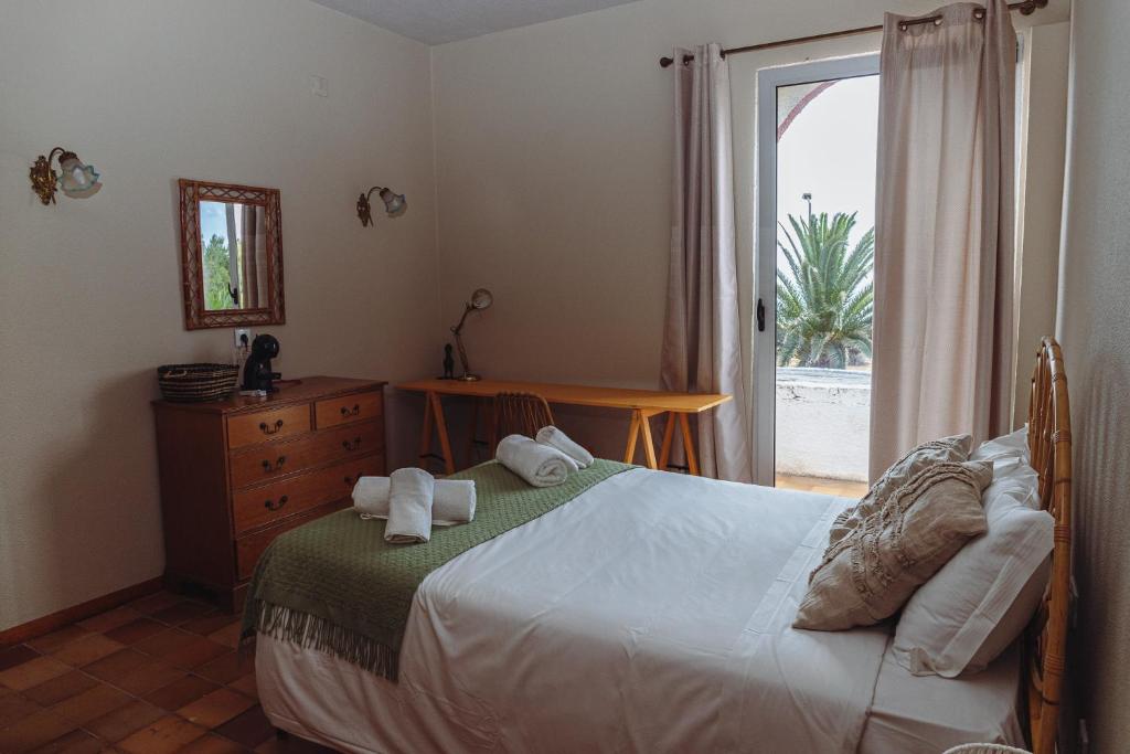 a bedroom with a bed and a large window at Porto Santo Destination in Porto Santo