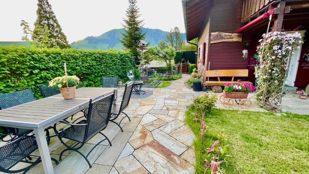 a patio with a table and chairs in a yard at The Swiss Paradise 2 Apartment with Garden, Whirlpool, and Mountain Panorama in Wirzweli