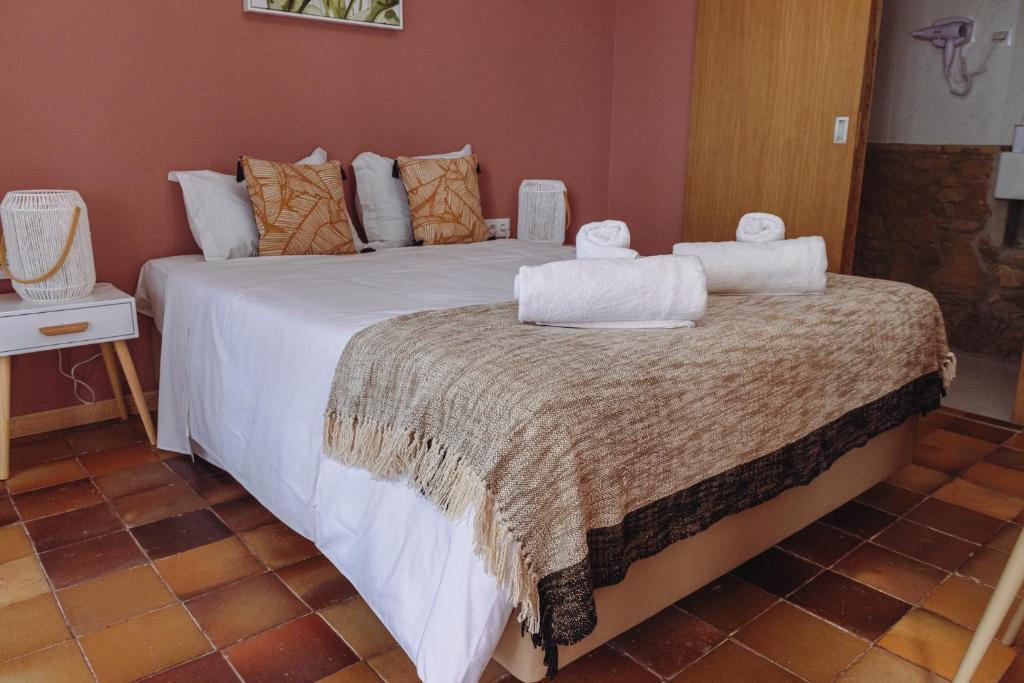 a bedroom with a large bed with towels on it at Porto Santo Destination in Porto Santo