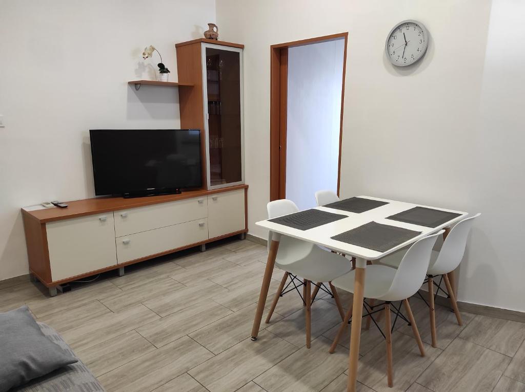 ein Wohnzimmer mit einem Tisch und Stühlen sowie einem TV in der Unterkunft Apartment Lana in Izola