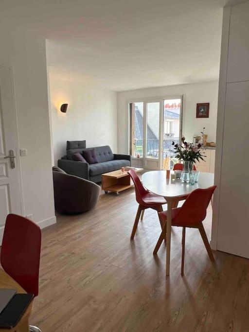 sala de estar con mesa y sillas en Superbe appartement entièrement rénové, en París