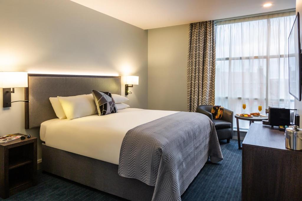 um quarto de hotel com uma cama grande e uma janela em Mercure Bridgwater em Bridgwater