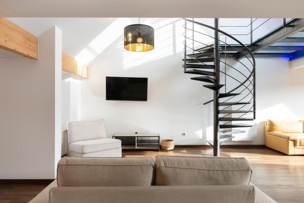 sala de estar con sofá y escalera de caracol en Le Loft Du Gibet en Montigny-lès-Metz