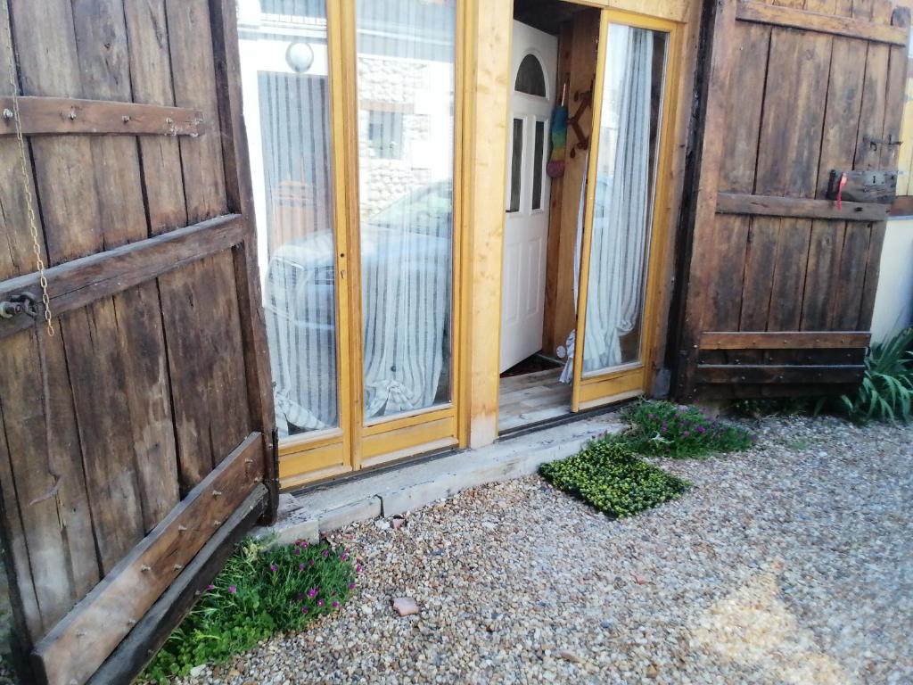 una entrada a una casa con 2 puertas de madera en Le petit loft, en La Croix-en-Touraine