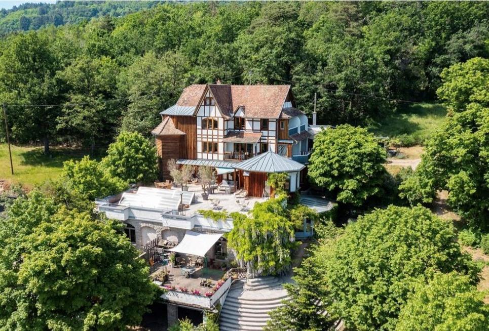 an aerial view of a large house with trees at Le Manoir des Sens - Forêt de Bergheim in Thannenkirch