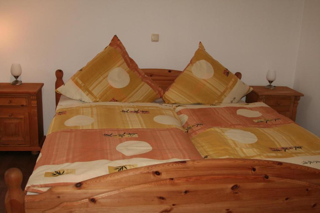 Un dormitorio con una gran cama de madera con sábanas marrones. en Pension Gina, en Görlitz