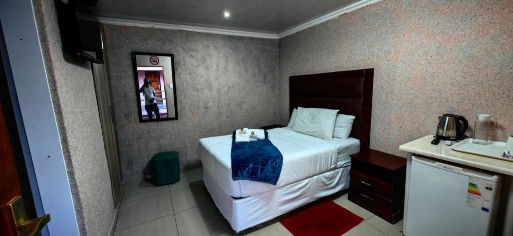 a hotel room with a bed and a sink at Princeville Guest Lodge in Soweto
