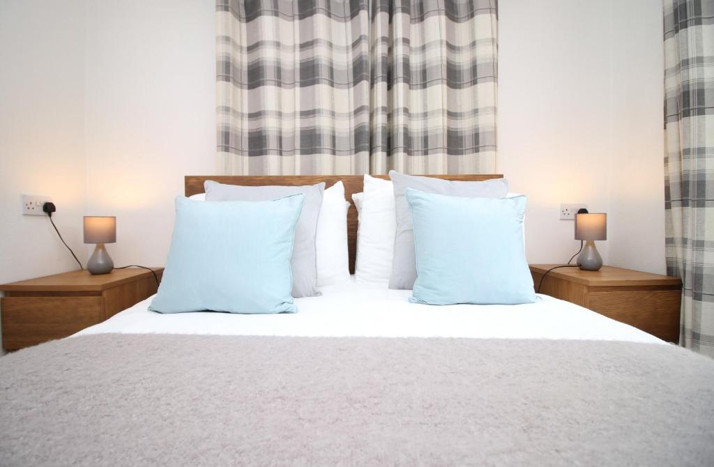 a bedroom with a white bed with white pillows at The Cornish Nook by StayStaycations in Camelford