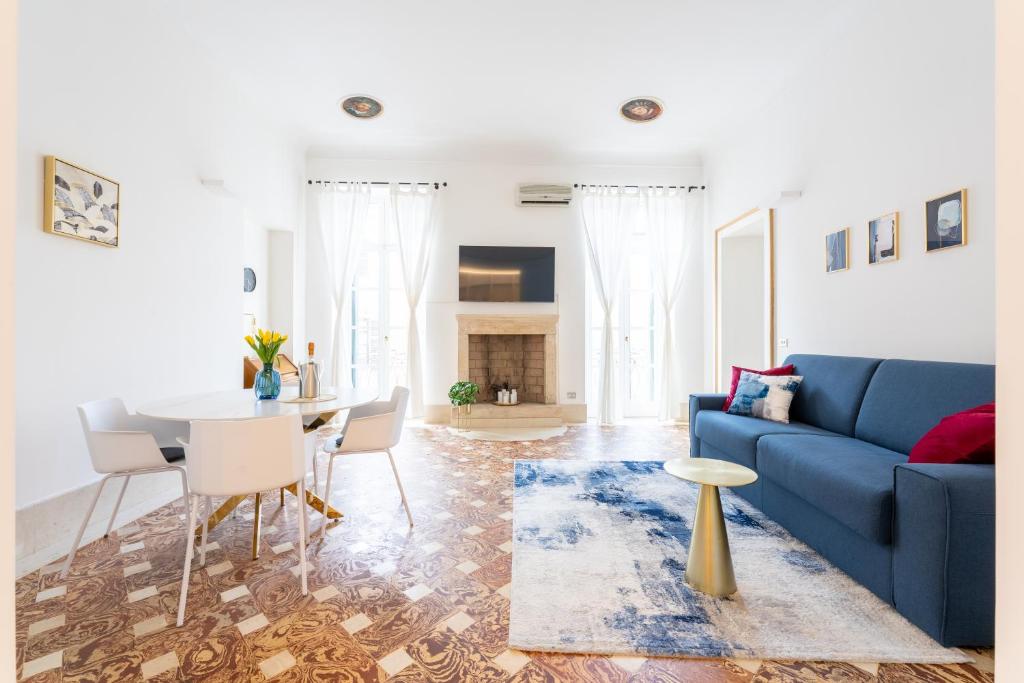 a living room with a blue couch and a table at [2 minutes walk from Verona Arena]Luxury Apartment in Verona