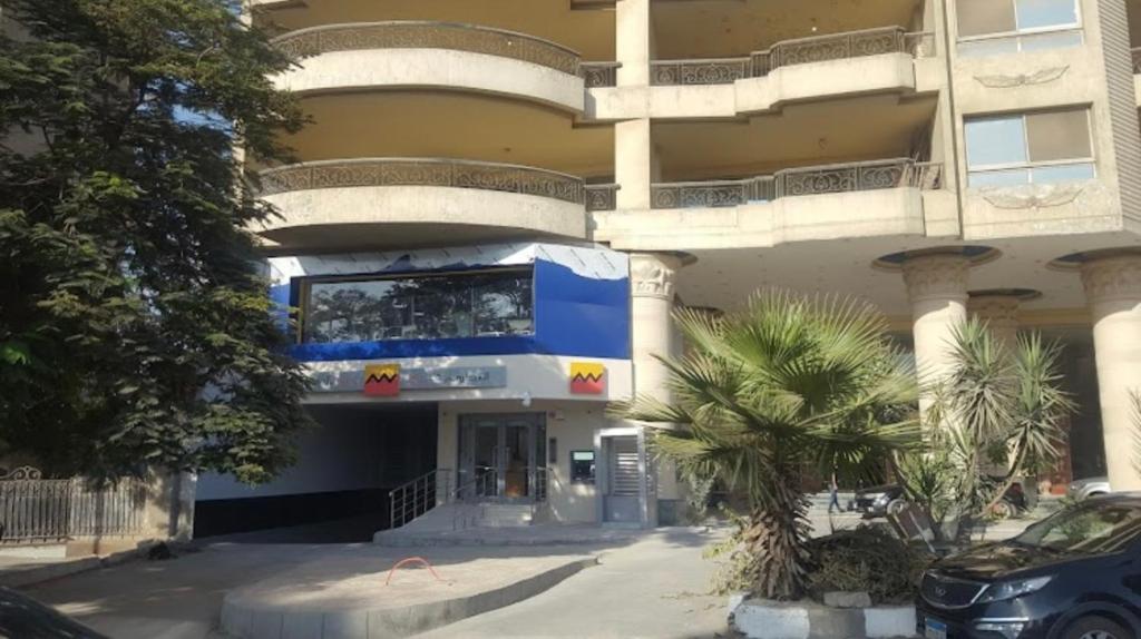niebiesko-biały budynek z palmą przed nim w obiekcie شقة فخمة علي كورنيش النيل - المعادي w Kairze