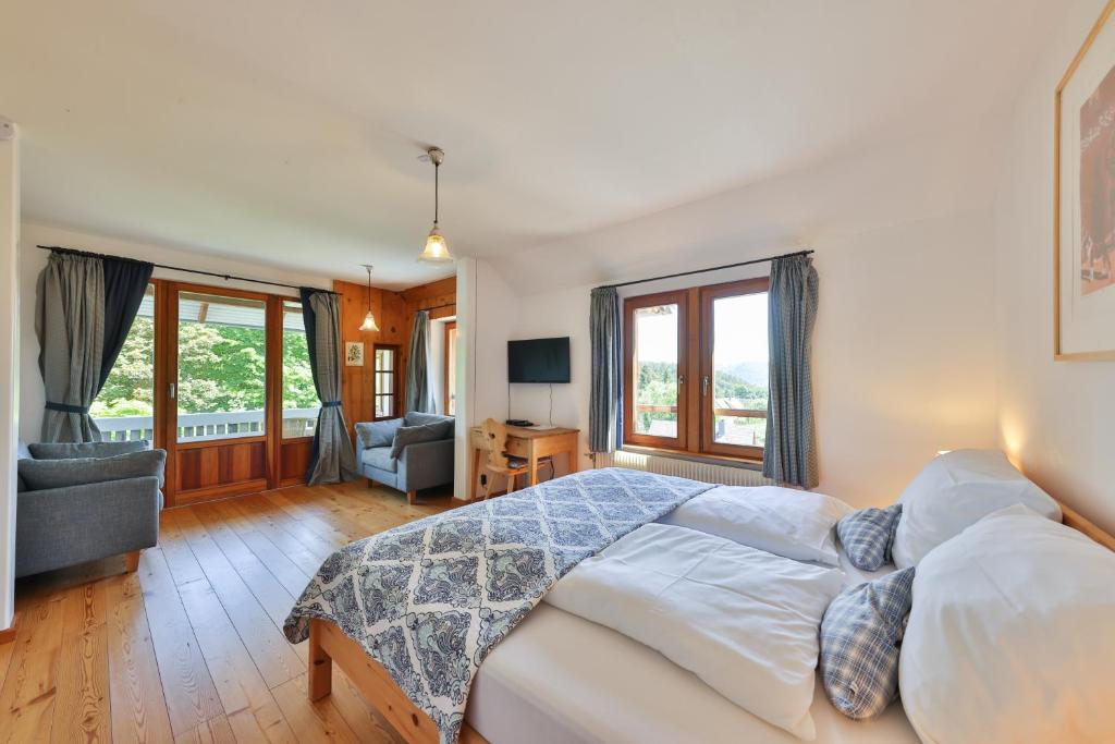 ein Schlafzimmer mit einem Bett und ein Wohnzimmer in der Unterkunft Les appartements du Manoir des Sens in Thannenkirch