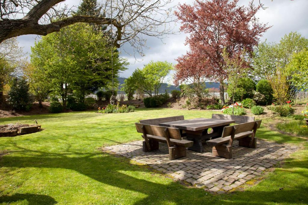 a picnic table and two benches in a park at Idyll am Weinberg in Rhodt unter Rietburg