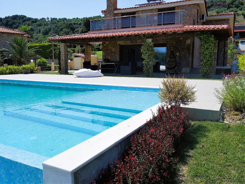 a large swimming pool in front of a house at Blue Dream Villa in Nea Skioni