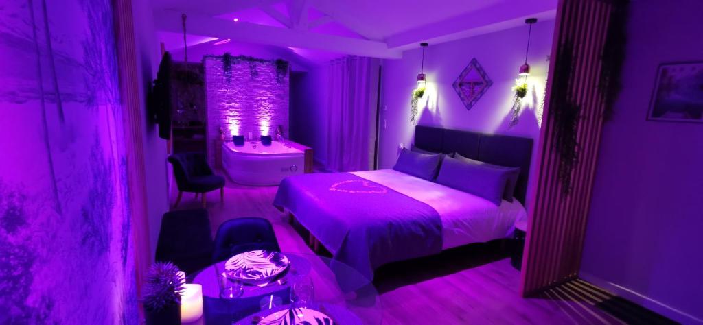 a purple bedroom with a bed and a bath tub at L'Essentiel - Love 85 in Talmont