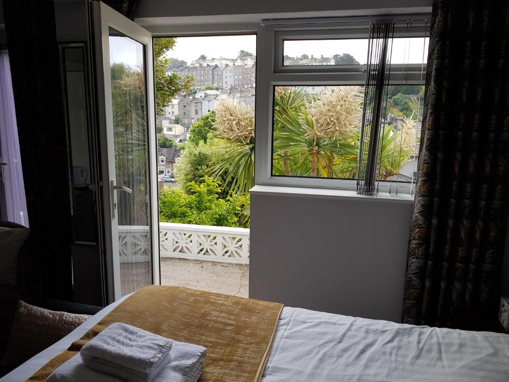 a bedroom with a bed and a large window at Barclay Court Guest House in Torquay