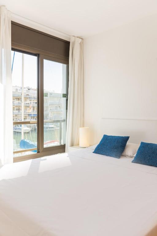 a bedroom with a large bed and a large window at Pierre & Vacances Empuriabrava Marina in Empuriabrava