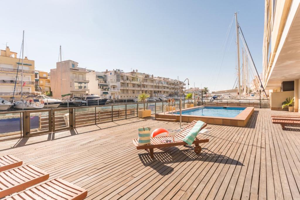 a deck with a chair and a pool on a boat at Pierre & Vacances Empuriabrava Marina in Empuriabrava