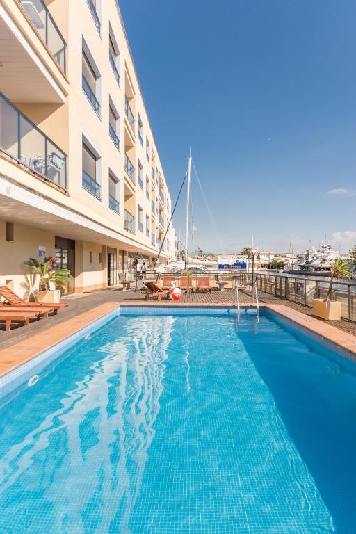 a swimming pool in front of a building at Pierre & Vacances Empuriabrava Marina in Empuriabrava