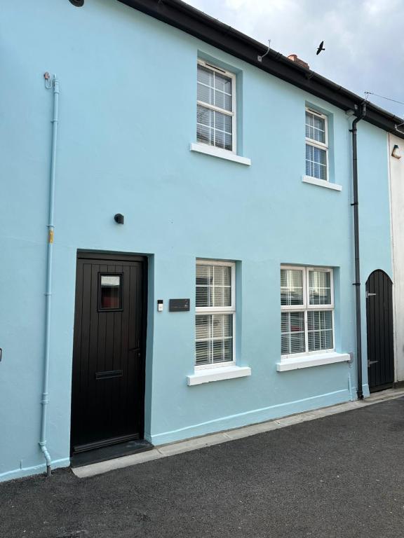 a blue house with a black door and windows at 2 hunters lane Donaghadee in Donaghadee