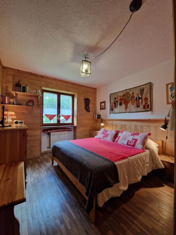 a bedroom with a bed with a red blanket at L'Atelier du Temps - Treinadan Appartement in Cogne