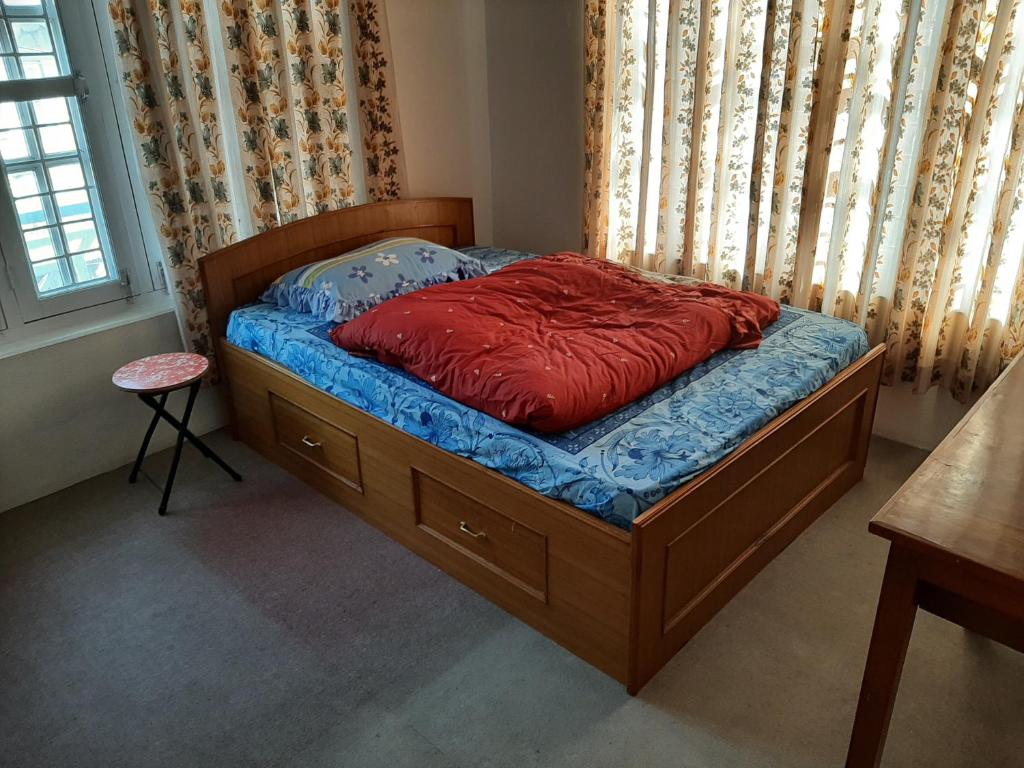Un dormitorio con una cama con una almohada roja. en juneli raat homestay pokhara en Pokhara