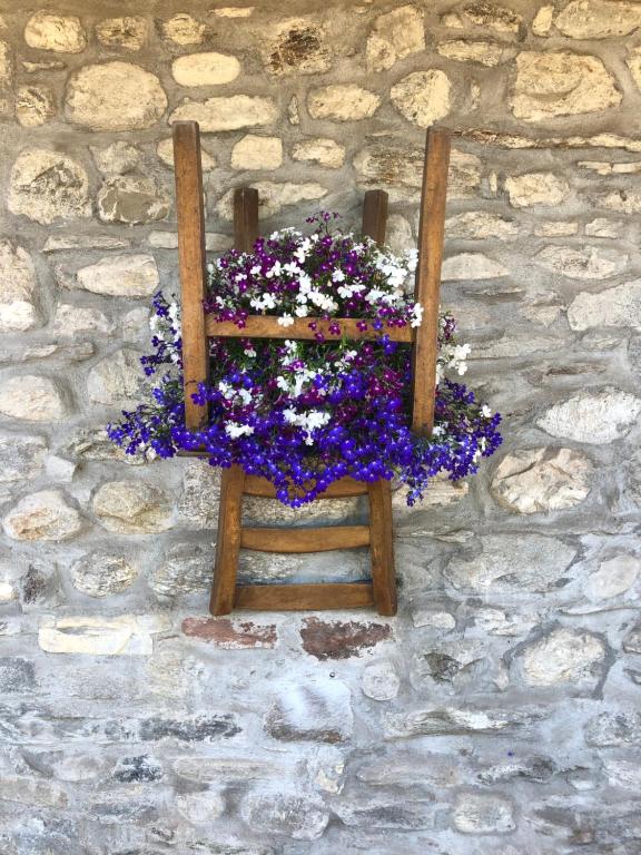 una cesta de flores colgada en una pared de piedra en Casa Nonna Elide, en Besozzo