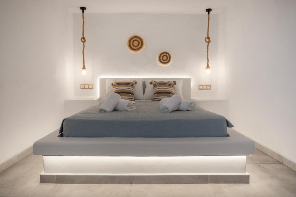 a white bedroom with a bed with two pillows at Feel Breeze in Mýkonos City