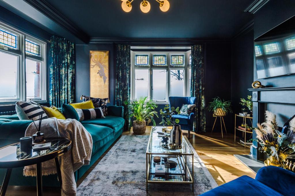 een woonkamer met een blauwe bank en een open haard bij Beautiful 4-bed Luxury Windsor Home by Casa by Grace, Amazing location, Perfect for large groups, Pet Friendly, sleeps 7-9! in Windsor
