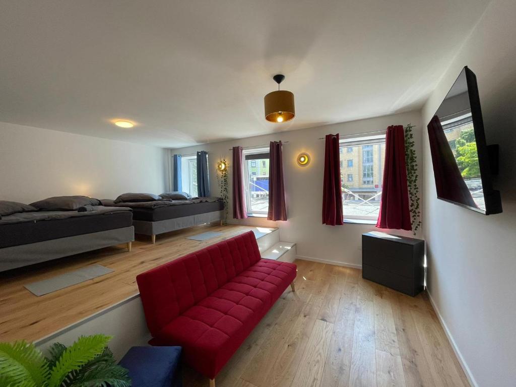 a living room with a red couch and a bed at Reeperbahn Apartments in Hamburg