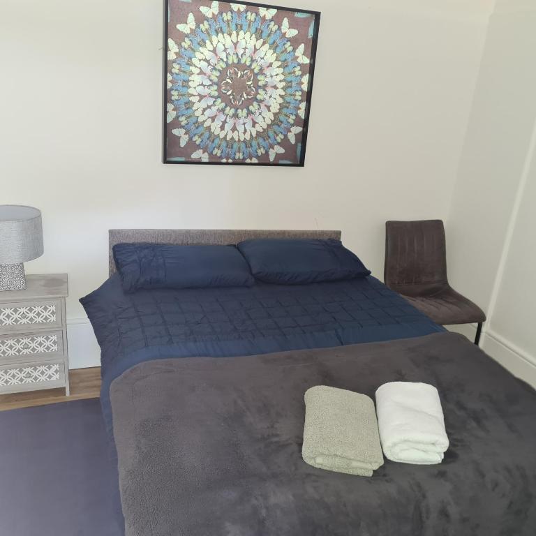 a bedroom with a blue bed with two pillows at Cozy apartment in Burton town centre in Burton upon Trent