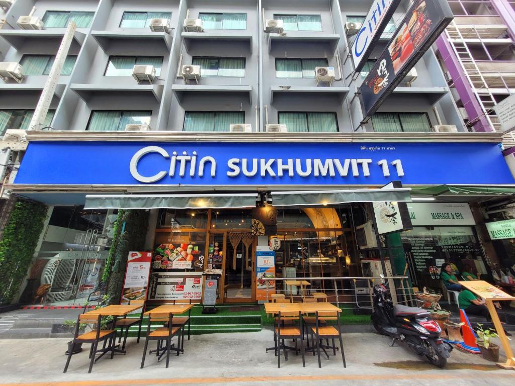 a restaurant with tables and chairs in front of a building at Citin Sukhumvit 11 Nana Bangkok by Compass Hospitality in Bangkok