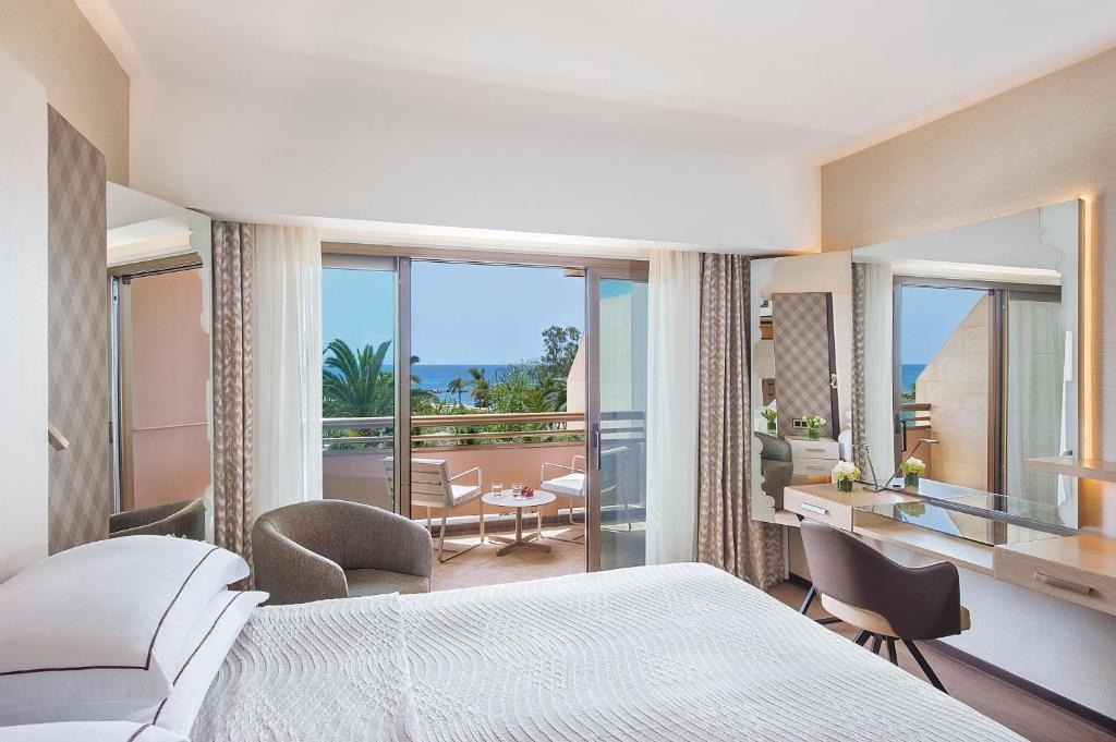 a bedroom with a bed and a view of a balcony at Four Seasons Hotel in Limassol