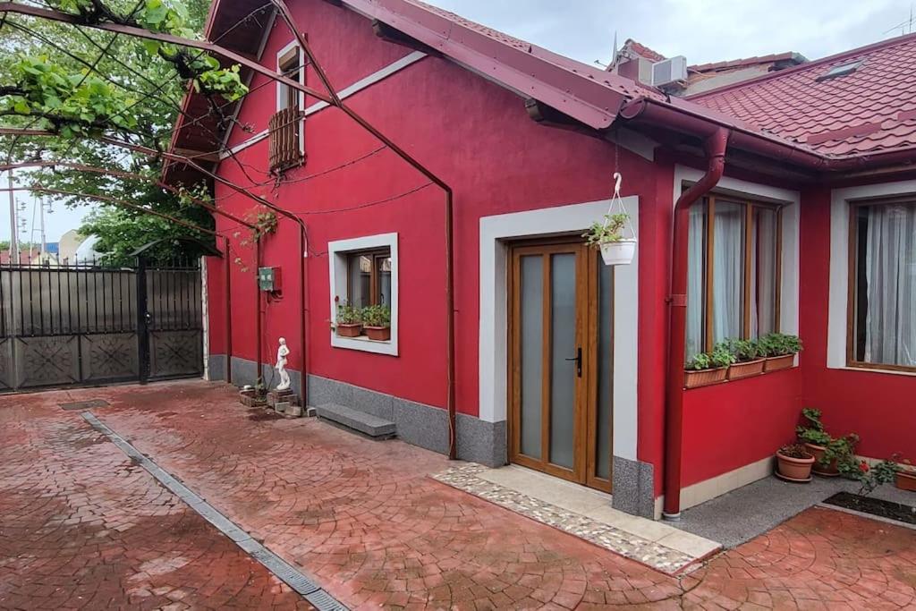 a red house with a dog standing in front of it at Casa in Oradea ! in Oradea