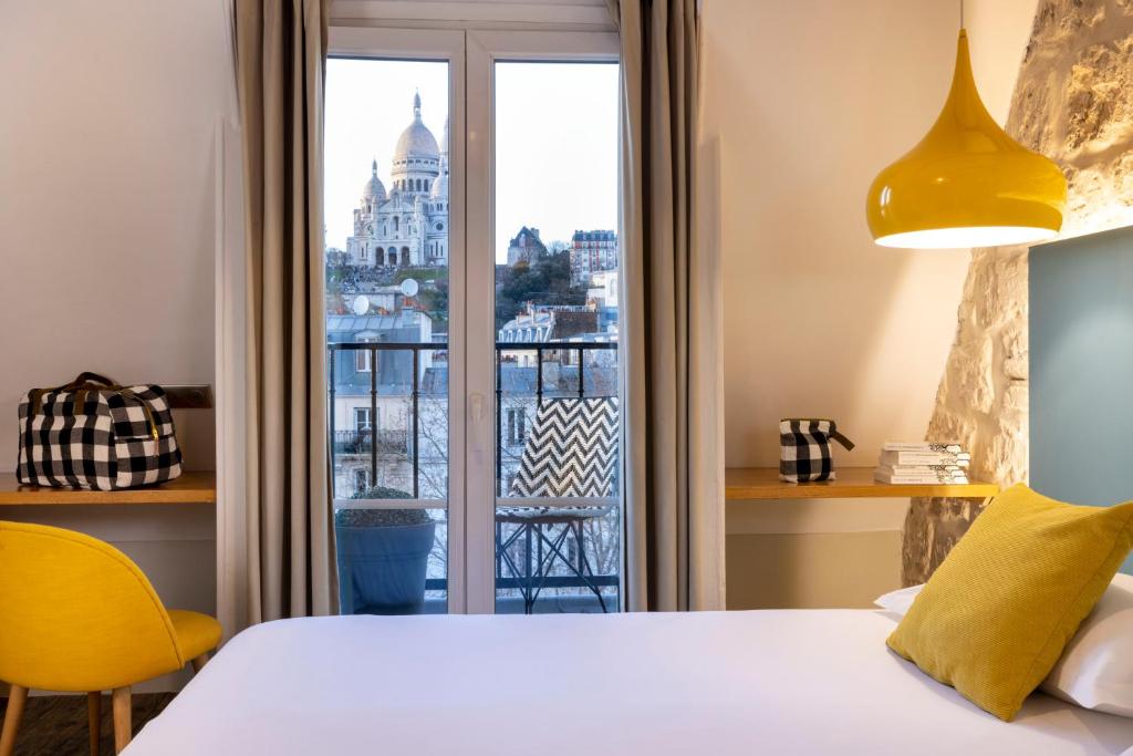 a bedroom with a bed and a large window at Le Regent Montmartre by Hiphophostels in Paris