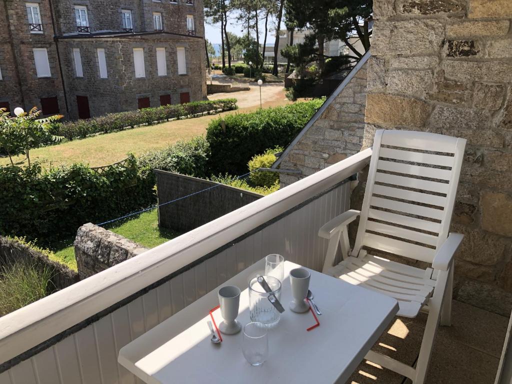 einen weißen Tisch und einen Stuhl auf dem Balkon in der Unterkunft Cromlech, Appartement avec petite vue mer, DT170 in Carnac