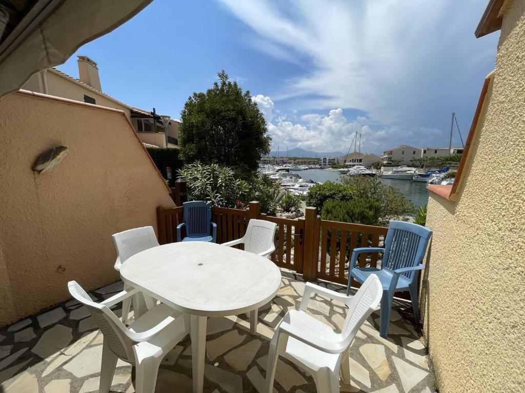 a table and chairs on a balcony with a view of a harbor at Villa Saint-Cyprien, 1 pièce, 6 personnes - FR-1-106-86 in Saint-Cyprien