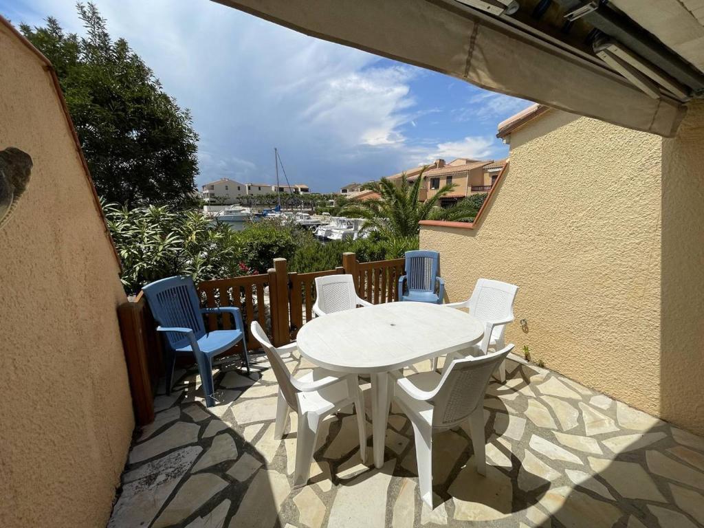 patio z białym stołem i krzesłami na balkonie w obiekcie Charmant Pavillon Familial avec Terrasse et Mezzanine - Proche Plage - Saint-Cyprien Plage - FR-1-106-86 w mieście Saint-Cyprien