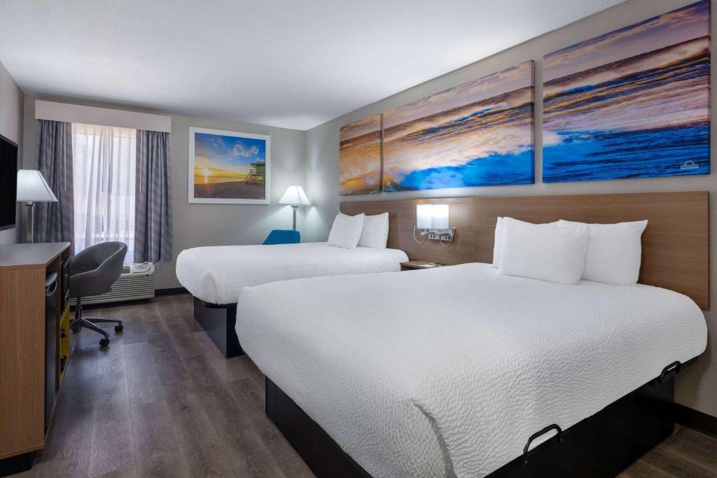 Un pat sau paturi într-o cameră la Days Inn & Suites by Wyndham Commerce