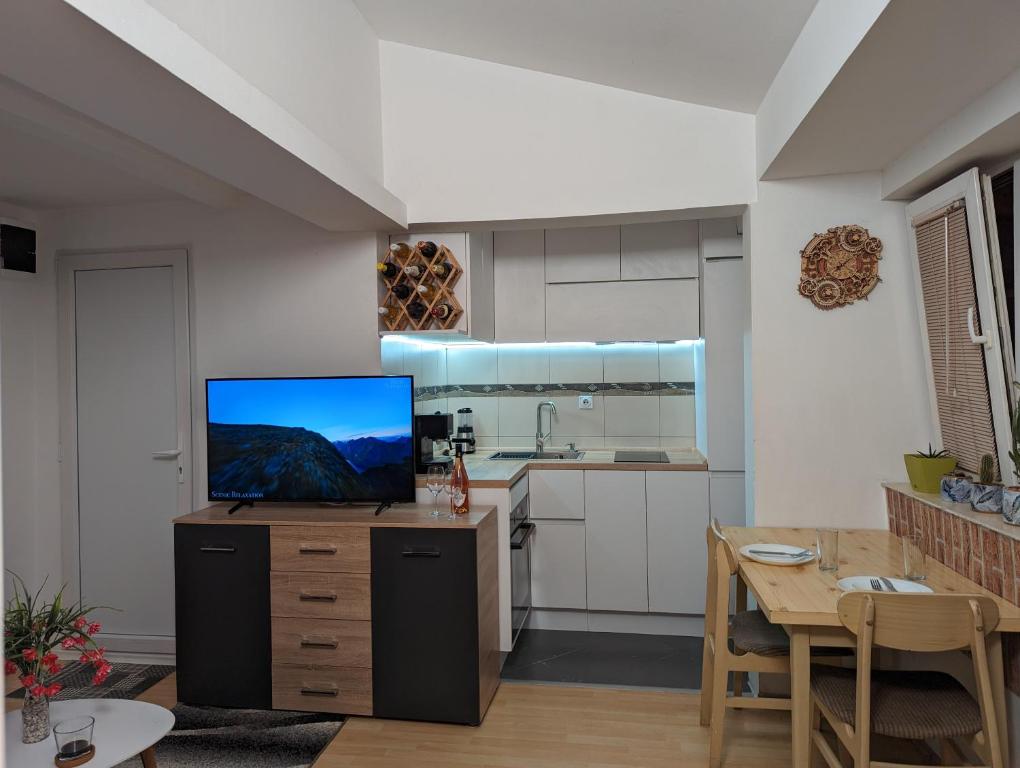 a kitchen with a tv on top of a wooden cabinet at Sunrise Apartment in Skopje