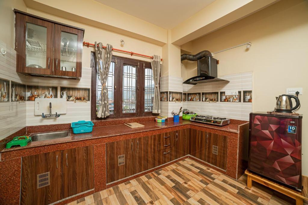 a large kitchen with wooden cabinets and a sink at Subedi Apartment in Pokhara