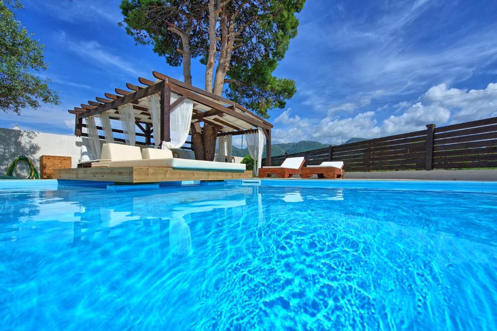 阿查拉維的住宿－Beach Villa Christina by PosarelliVillas，游泳池的顶部设有凉棚
