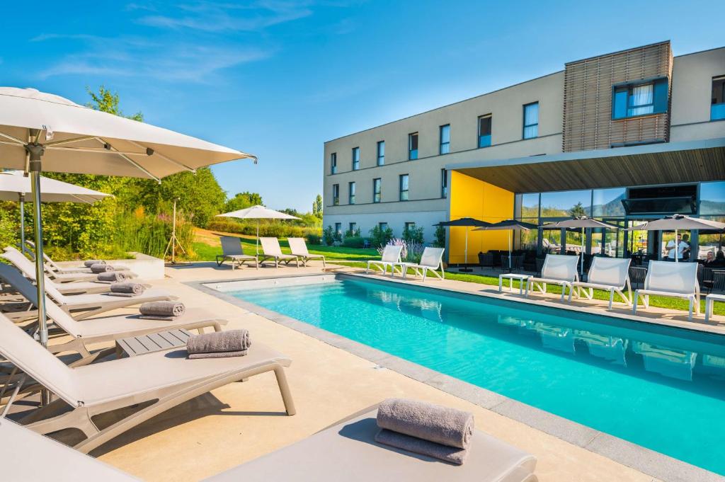 une piscine avec chaises et parasols à côté d'un bâtiment dans l'établissement Best Western Plus Hotel & Restaurant Les Humanistes Colmar Nord, à Sélestat