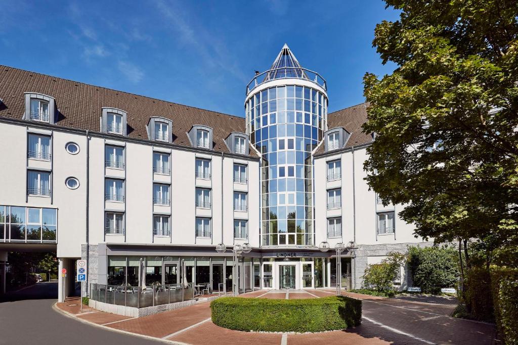 a large building with a glass tower on top of it at Lindner Hotel Dusseldorf Airport, part of JdV by Hyatt in Düsseldorf