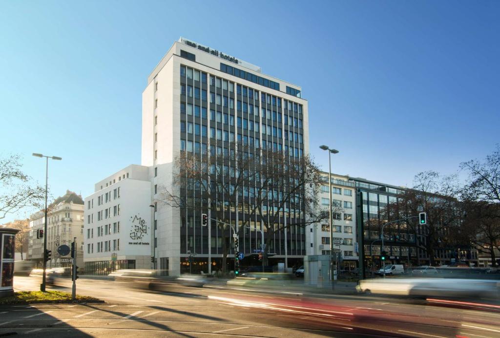 un edificio alto en una calle de la ciudad con coches en me and all hotel Dusseldorf, part of JdV by Hyatt en Düsseldorf