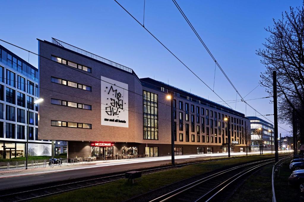 un edificio con vías de tren delante de él en me and all hotel Dusseldorf Oberkassel, part of JdV by Hyatt en Düsseldorf